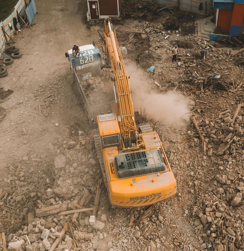 Excavator clearing demolition debris
